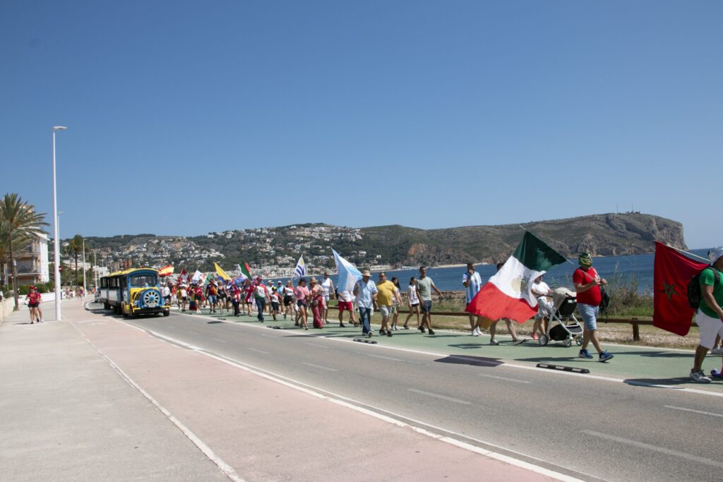 javea international festival march along the beach, with the tourist train driving past