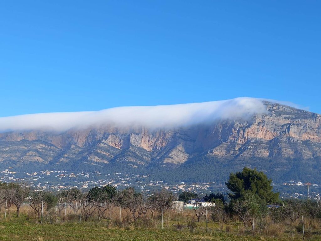 Javea's Montgo mountain with a cloud mountain.